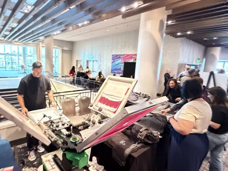 A close view of an automatic screen-print press head running at an event booth